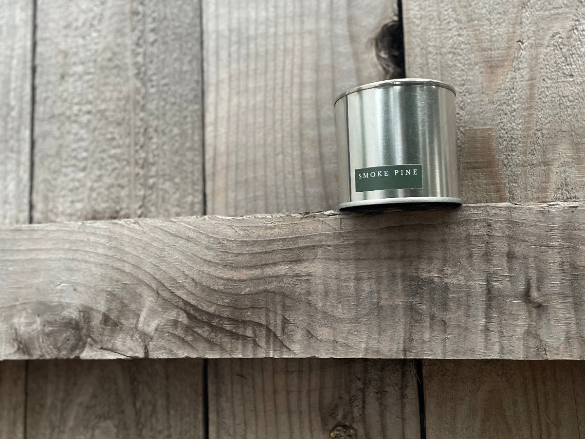Smoke Pine 01 candle by HOT WAX, steel tin with back label on natural wood surface